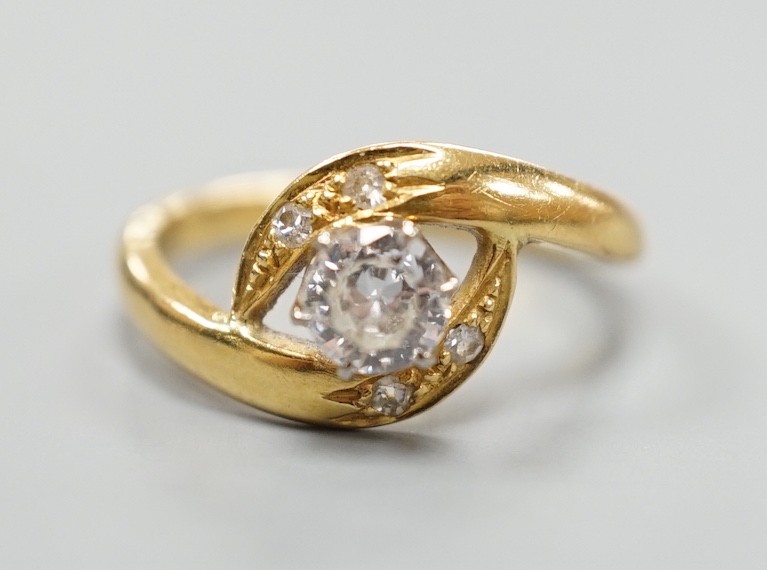 A continental yellow metal and single stone diamond set ring, with diamond set crossover shoulders, size I, gross weight 3.2 grams.